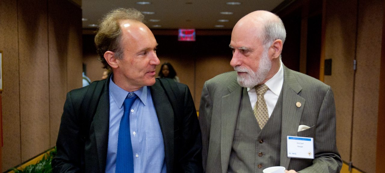 two men wearing suits talking to each other