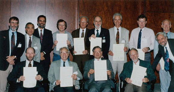 A group of people holding a piece of paper and posing for a photo