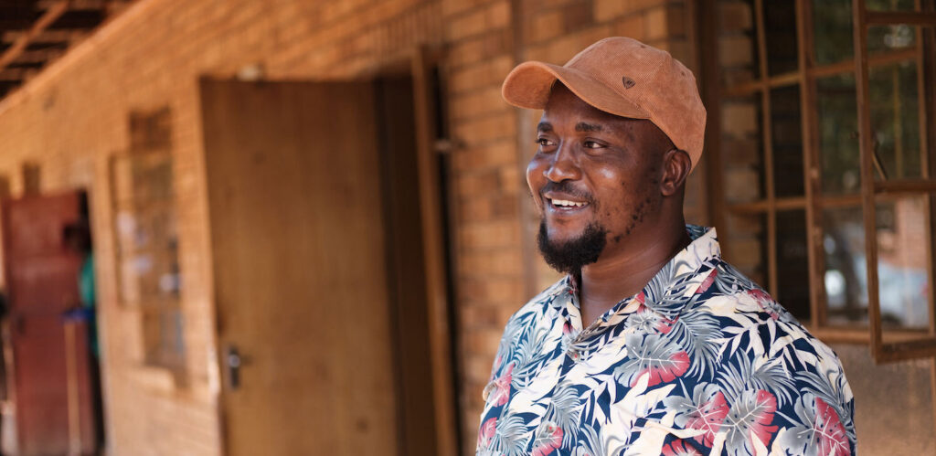 a man with a brown cap smiling