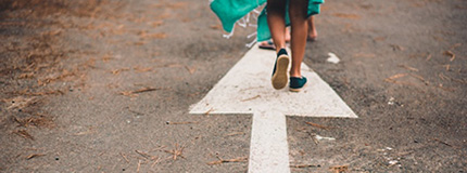 Feet on a road arrow