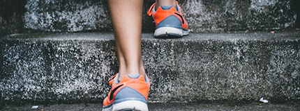 legs in sneakers running up the steps